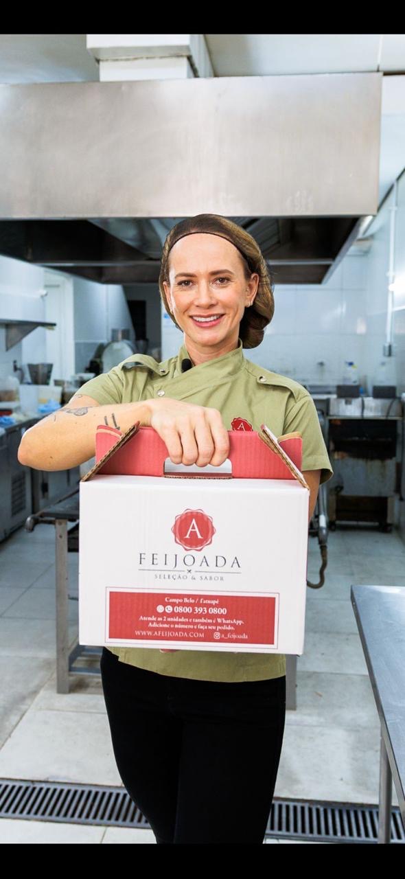 Chef Shirley Martins segurando a caixa especial de entrega A Feijoada